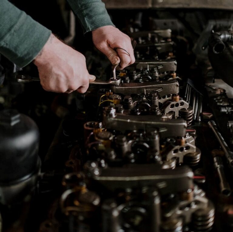 Technician performing construction Equipment Service and Maintenance on a cylinder head