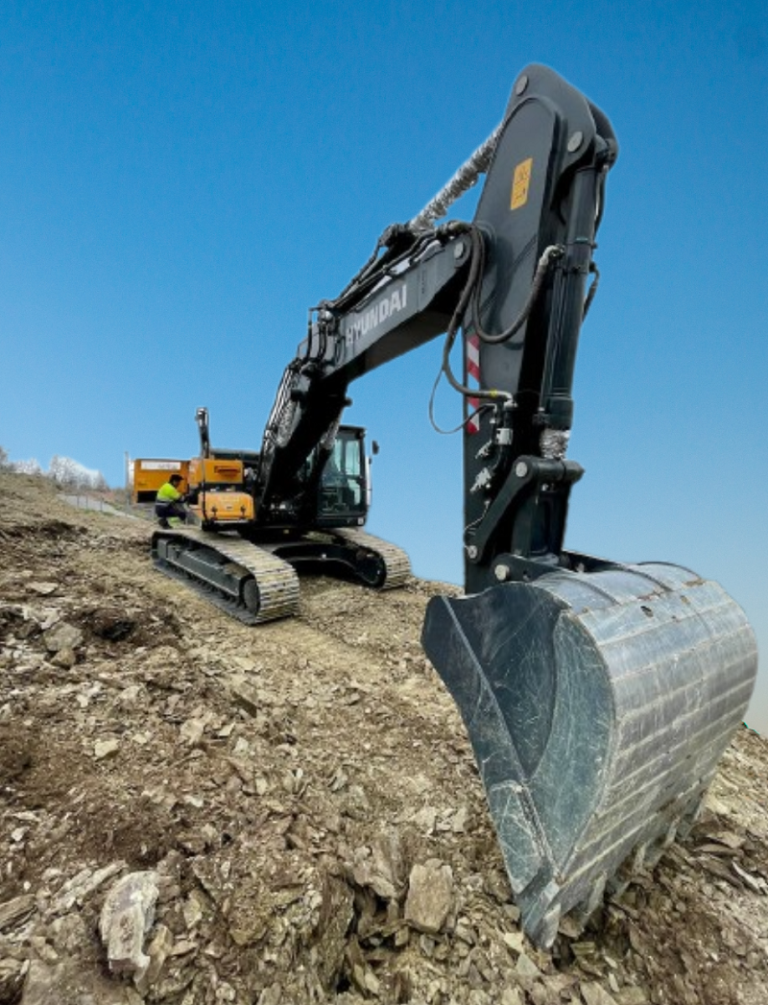 Excavator getting repaired in the field by a technician.